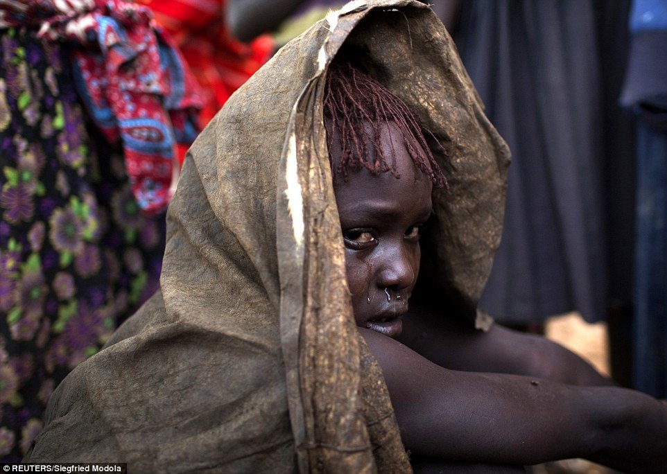 Tearful: One of the young girls, covered in an animal skin, cries after being circumcised. The practice was outlawed three years ago