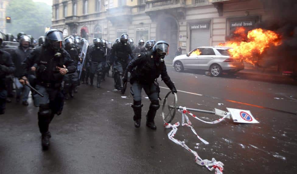 Italian anti-riot policemen run during a rally against Expo 2015 in Milan