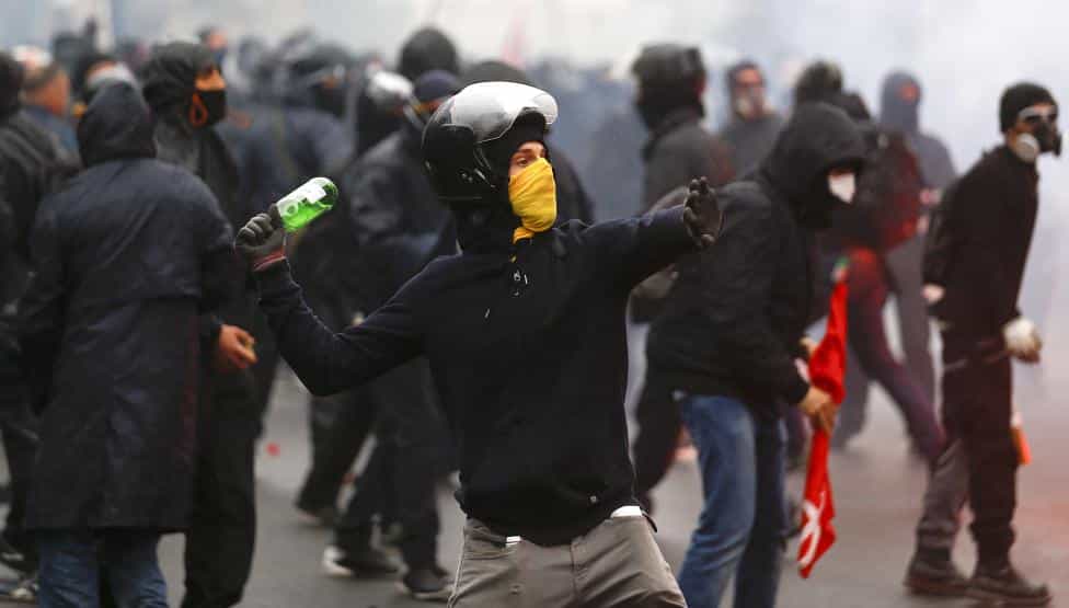 A protester throws a bottle during a rally against Expo 2015 in Milan
