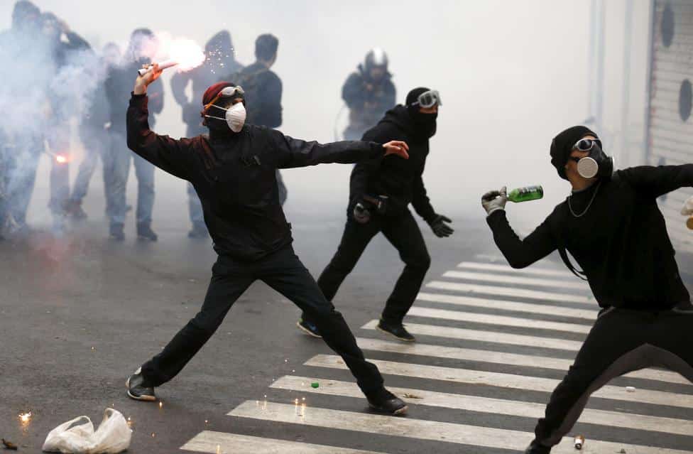Protesters throw bottles and flares during a rally against Expo 2015 in Milan