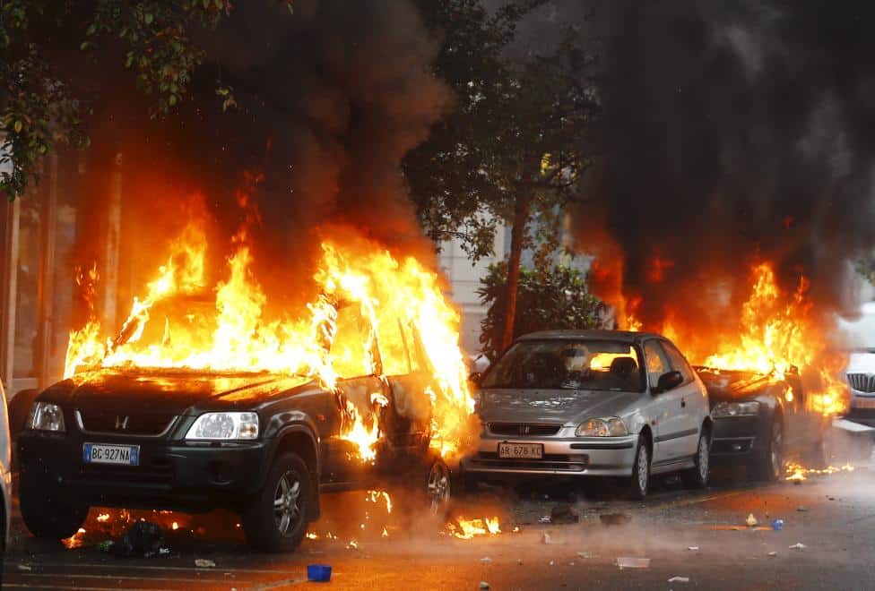 Cars are set on fire by protesters during a rally against Expo 2015 in Milan